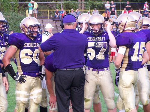 Coach Terry Haas goes over strategies with his defense during a timeout in the Sept. 6 contest against Constantine.