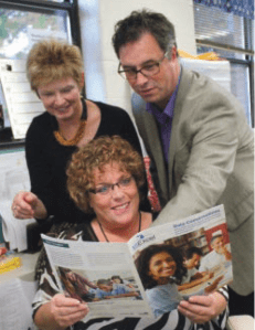 Jamie Masco, an instructional consultant at SunsetSchool who helped forge the plan for improvement along with Principal Pat Moreno and Grant Chandler of the MSU College of Education, look over the brochure that describes the focus school effort at Sunset Lake School.