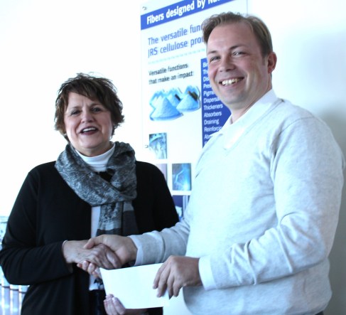 Sue Kuiper is presented with a check from Thorston Willmann, general   manager of the Schoolcraft branch of J. Rettenmaier.