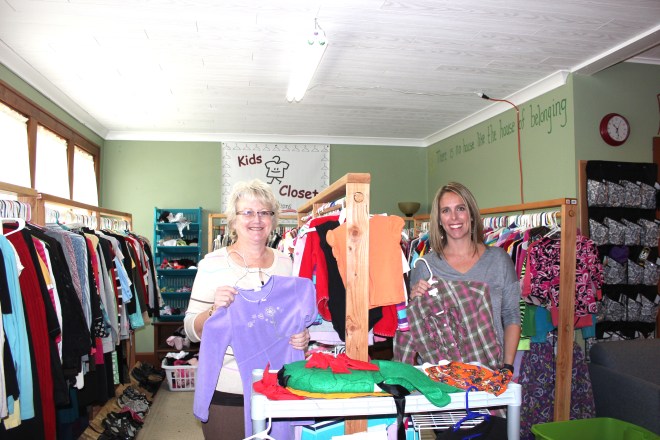 Penny Allen and Adrian McClelland display clothes that area families can have for free by coming to Kids Closet on the fourth Tuesday of each month.