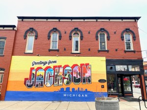 A postcard mural for the city of Jackson, painted on a brick building.