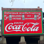 A hand painted mural reads Drink Coca-Cola.