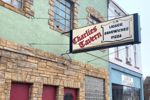 A building sign reads Charlie's Tavern - Liquor, Sandwiches, Pizza.