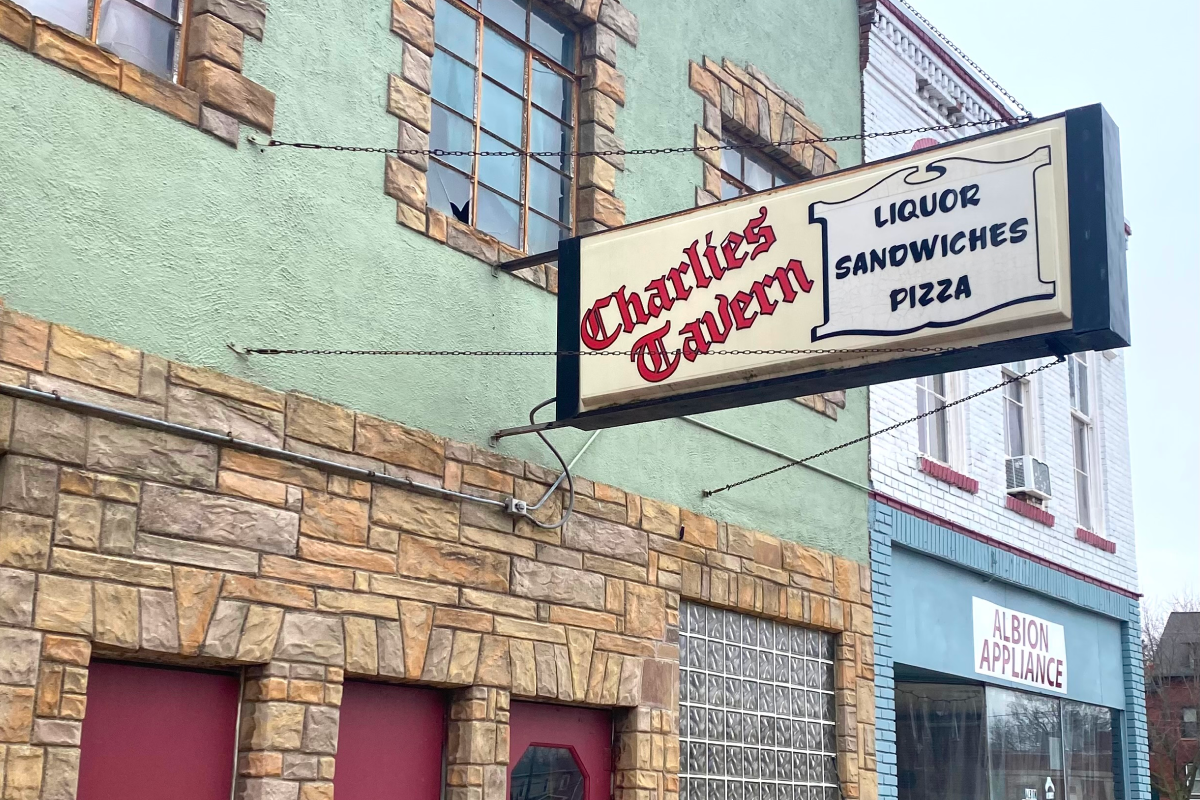 SCN_Article_Feat_OntheRoadAgain_0925 A building sign reads Charlie's Tavern - Liquor, Sandwiches, Pizza.