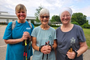 Three women smile out on the hiking trail.