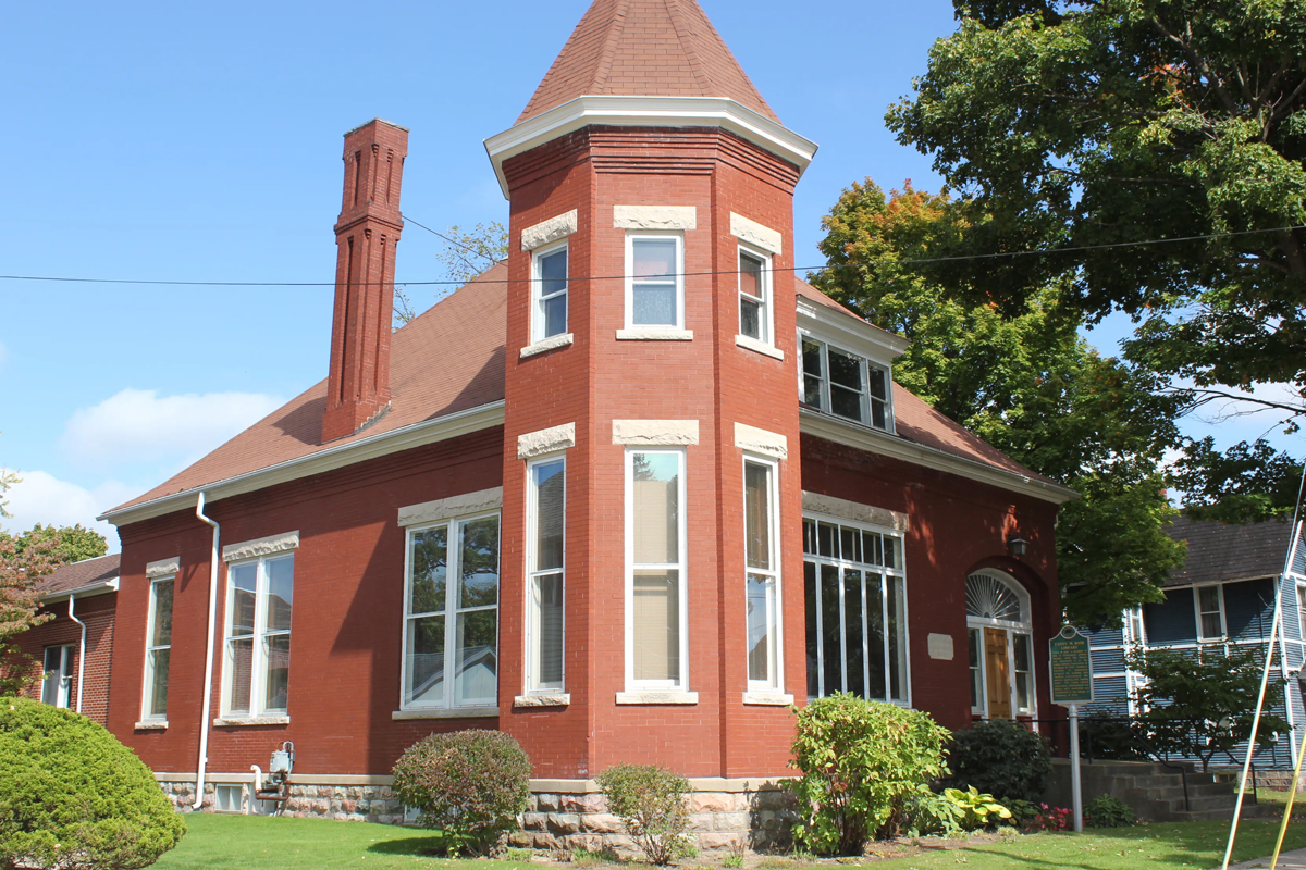 A brick building with a spire in the middle.
