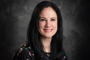 A woman with dark hair smiling.