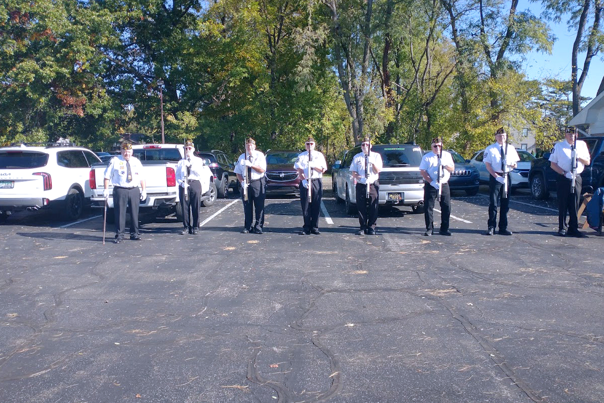 veteransday_vix Eight veterans in formal attire stand in formation with rifles.