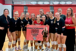 A volleyball team holds a banner honoring one of their own, Jenna Schramer.