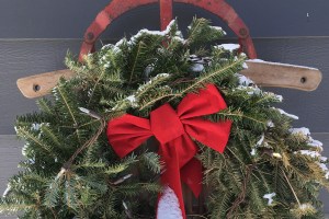 A Christmas wreath hung on a tobaggon.
