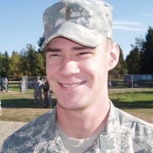 A smiling man in camouflage uniform.