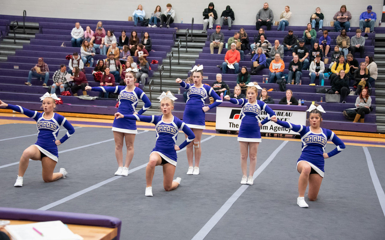 Several purple-clad cheerleaders perform.