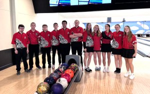 A bowling team standing in a lane.
