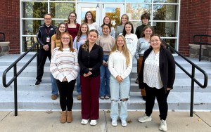 A group of high school students poses on the steps.