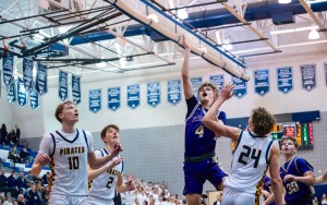Basketball players leap into the air desperate to make a basket.
