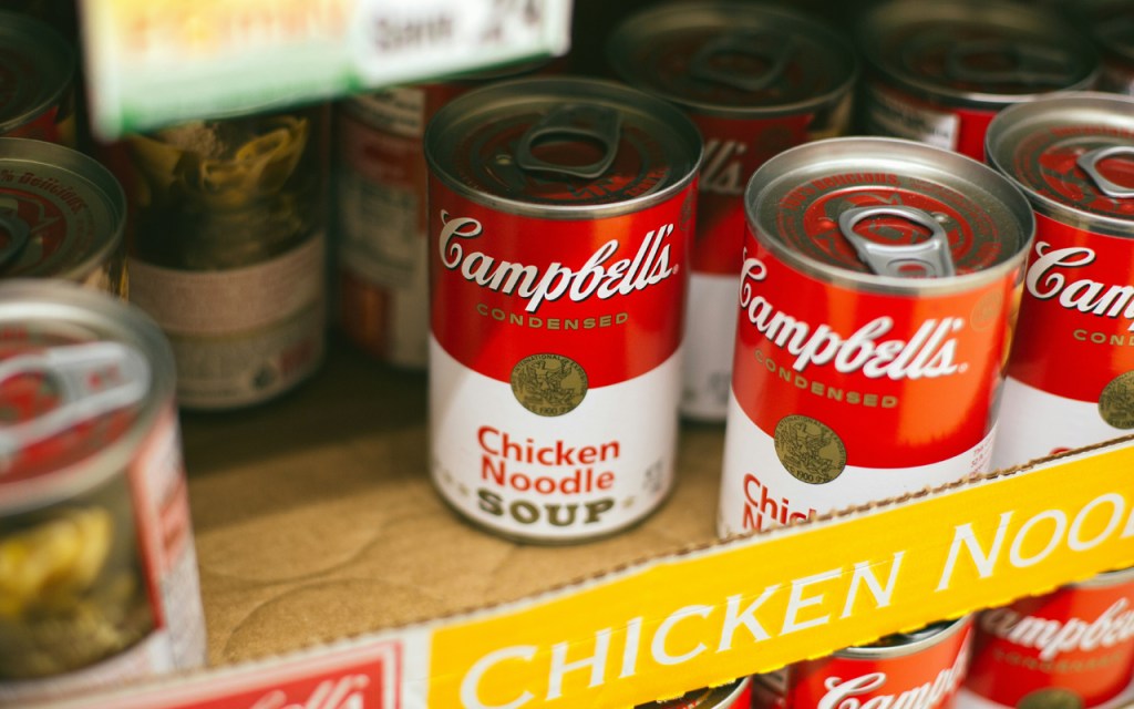 Several red soup cans in a box.