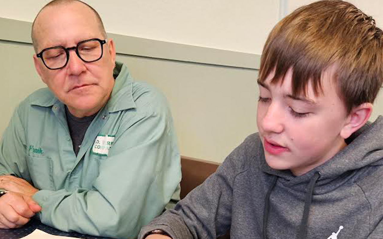 A man and a teenager read beside each other.