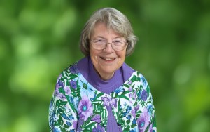 An image of a woman with glasses and a flowered shirt.