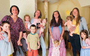 Four moms stand with their eight young kids of varying ages.