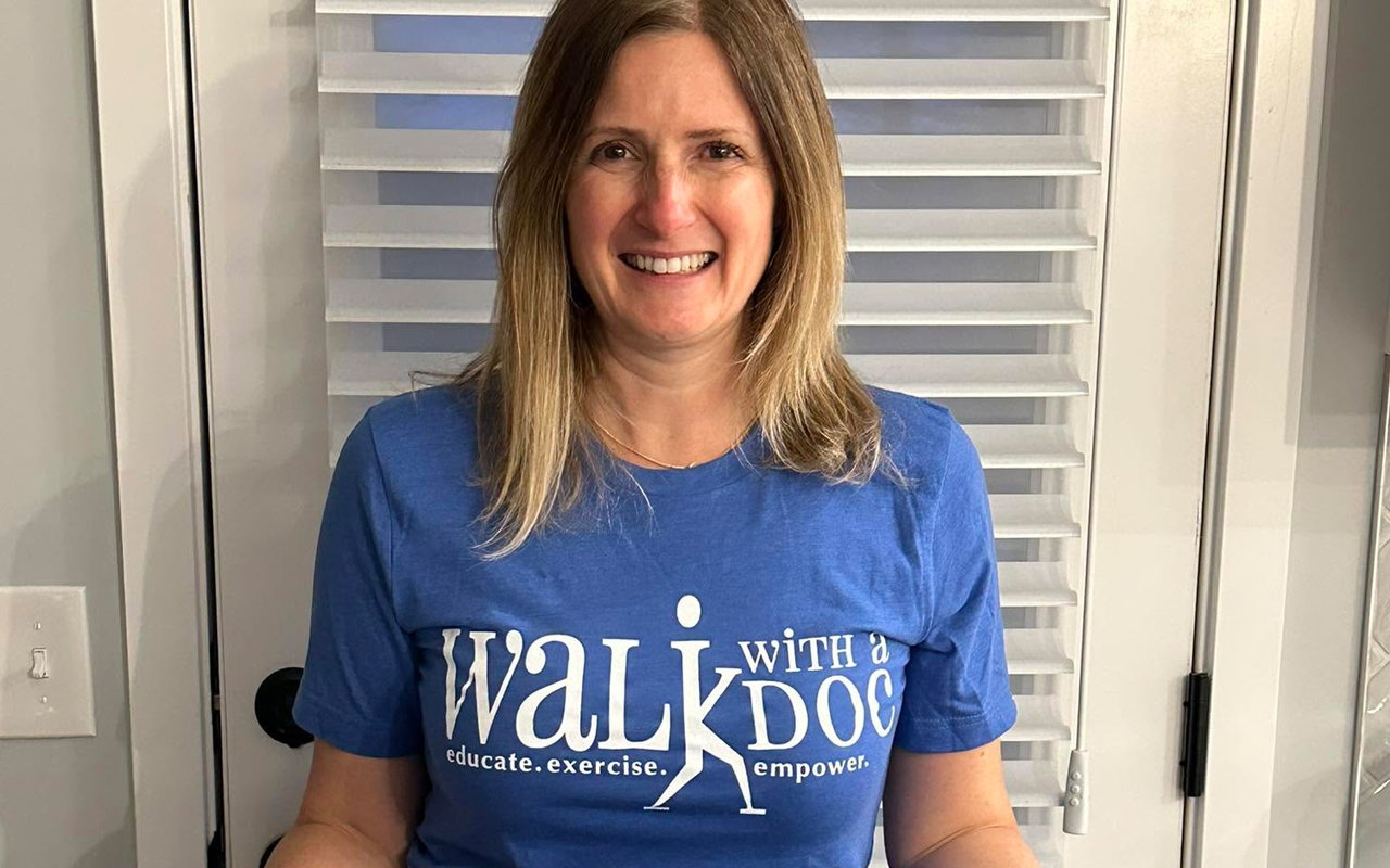 A woman in a blue t-shirt that reads "Walk with a Doc."