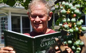 A man reading a book in a garden.