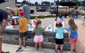 Four kids work on outdoor art projects.