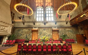 A dining room at the Biltmore Estate filled with red chairs and elaborate chandeliers.