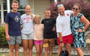 A family stands in a line, four children and a father and mother.