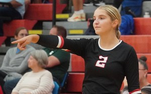 A black-uniformed volleyball player points their finger.